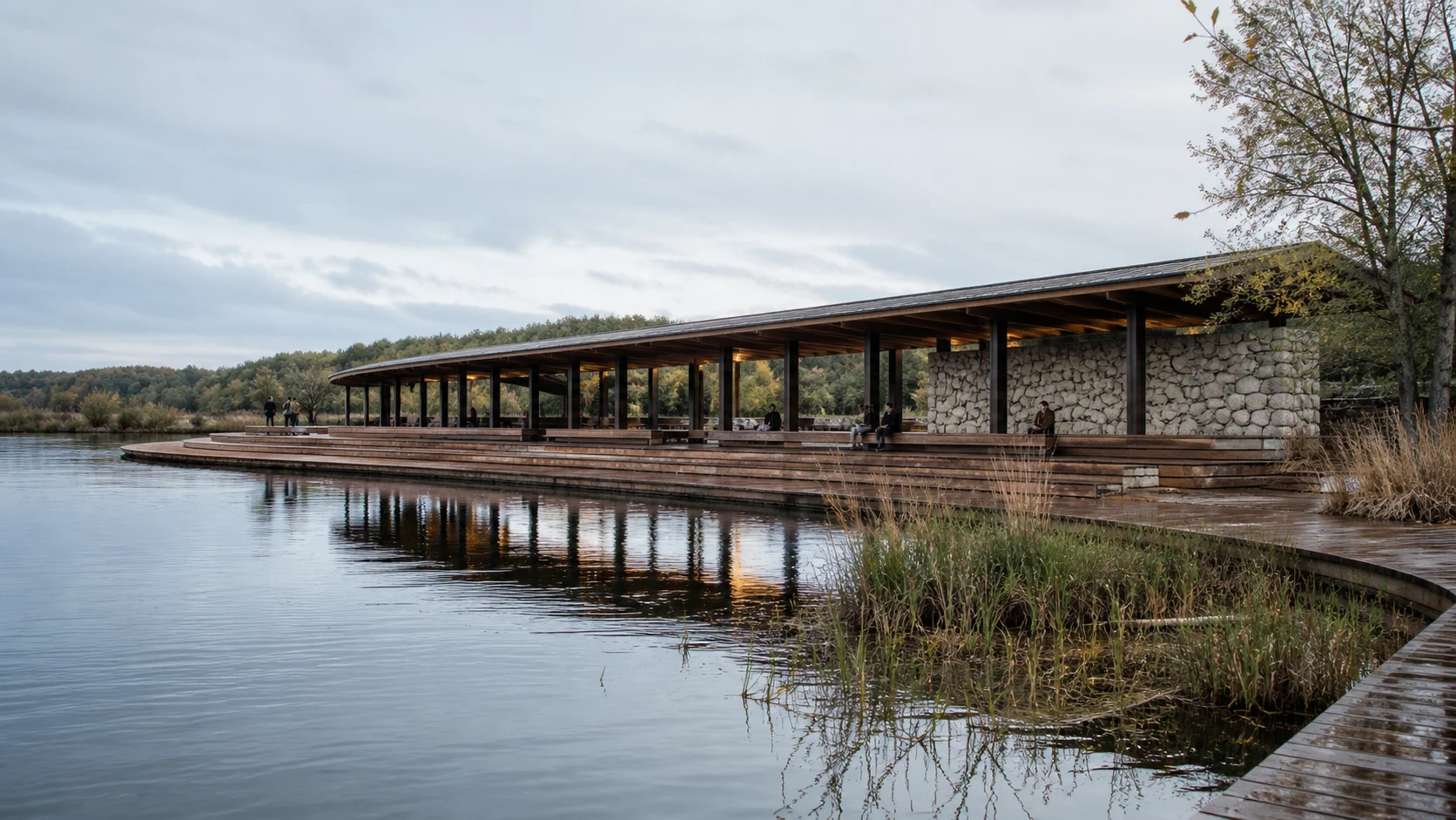 Low timber and stone public pavilion wrapping a calm lake edge